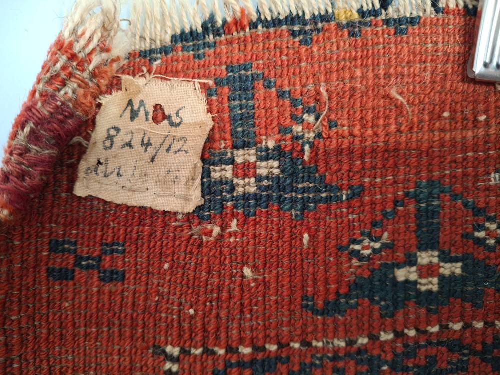 A rectangular antique handwoven wool Ersari Turkoman chuval face featuring fifteen stepped octagonal gul motifs arranged on a deep rust-red field within geometric borders. View XII