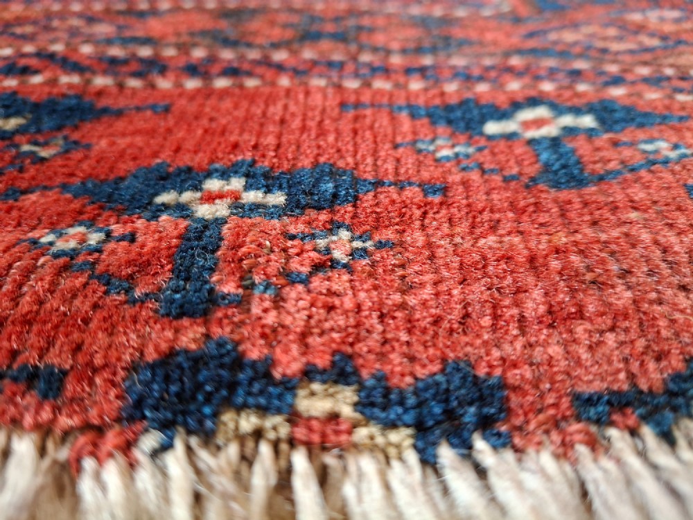 A rectangular antique handwoven wool Ersari Turkoman chuval face featuring fifteen stepped octagonal gul motifs arranged on a deep rust-red field within geometric borders. View XV