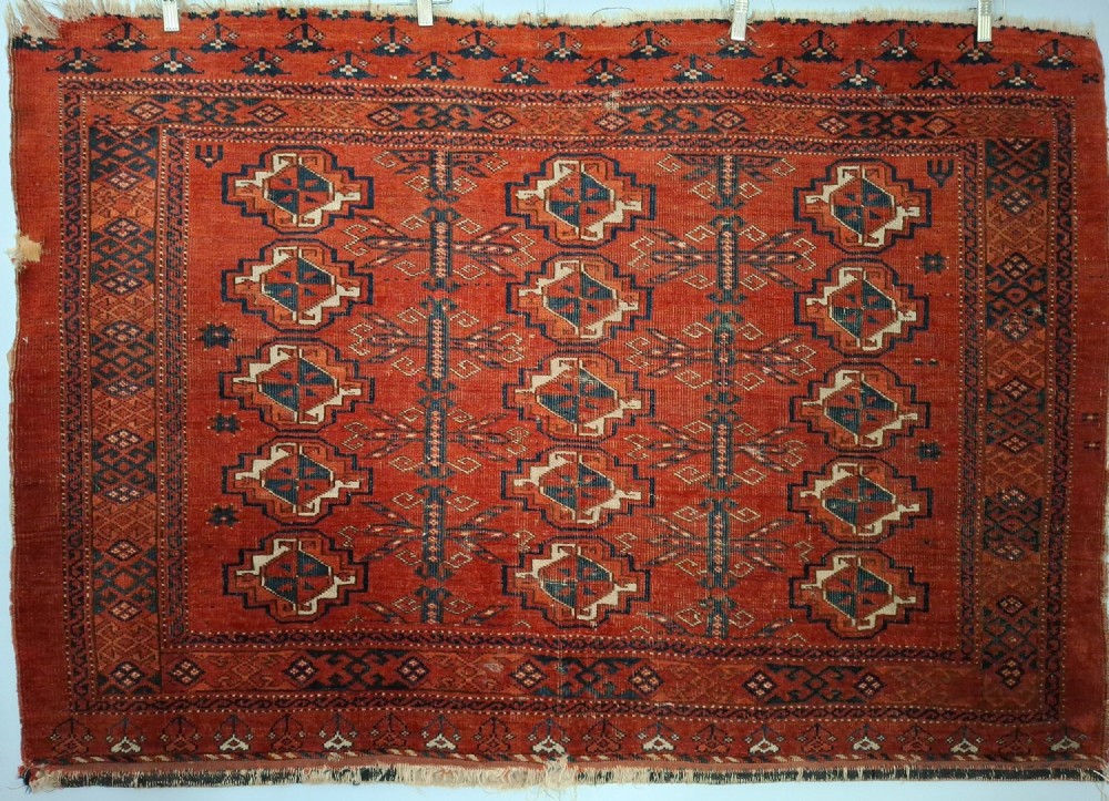A rectangular antique handwoven wool Ersari Turkoman chuval face featuring fifteen stepped octagonal gul motifs arranged on a deep rust-red field within geometric borders. View II