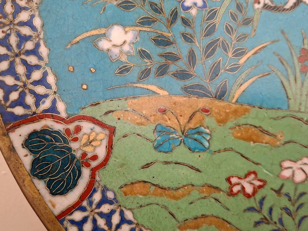 A circular Japanese cloisonne enamel decorative plate decorated with two wading birds surrounded by flowers against a turquoise ground with an ornamental geometric border. View VII