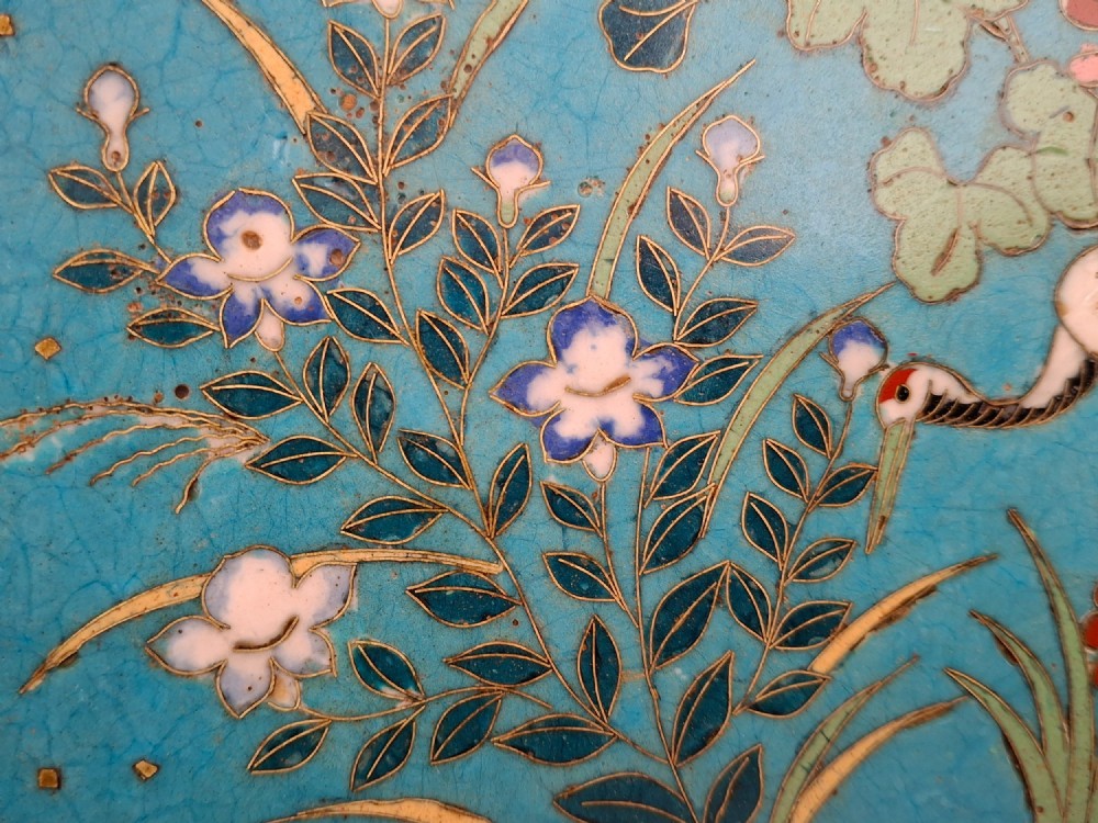 A circular Japanese cloisonne enamel decorative plate decorated with two wading birds surrounded by flowers against a turquoise ground with an ornamental geometric border. View VIII