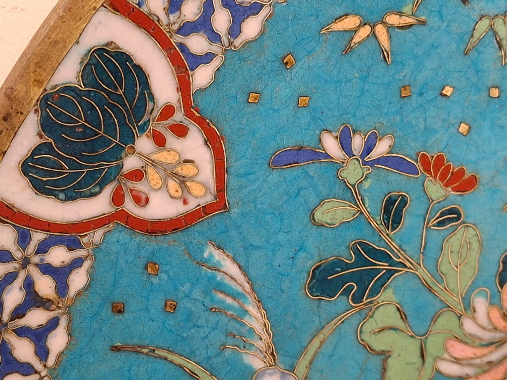 A circular Japanese cloisonne enamel decorative plate decorated with two wading birds surrounded by flowers against a turquoise ground with an ornamental geometric border. View XI