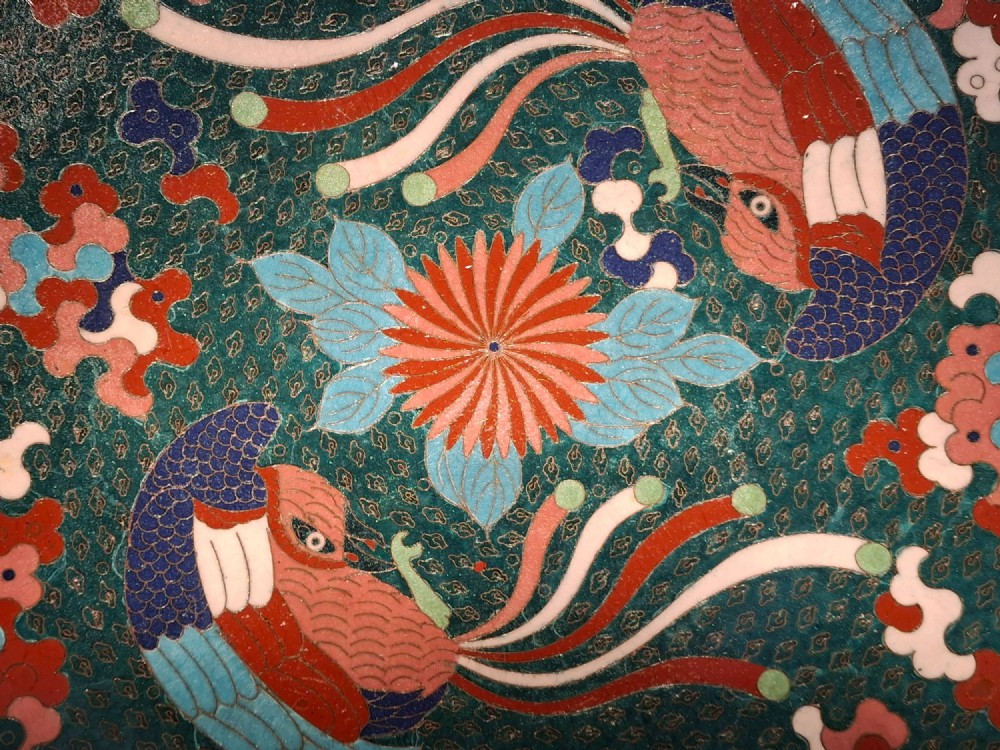 A circular antique Japanese cloisonne enamel charger decorated with two colourful Ho-o phoenix birds and a central floral chrysanthemum motif against a dark teal pattern. View II