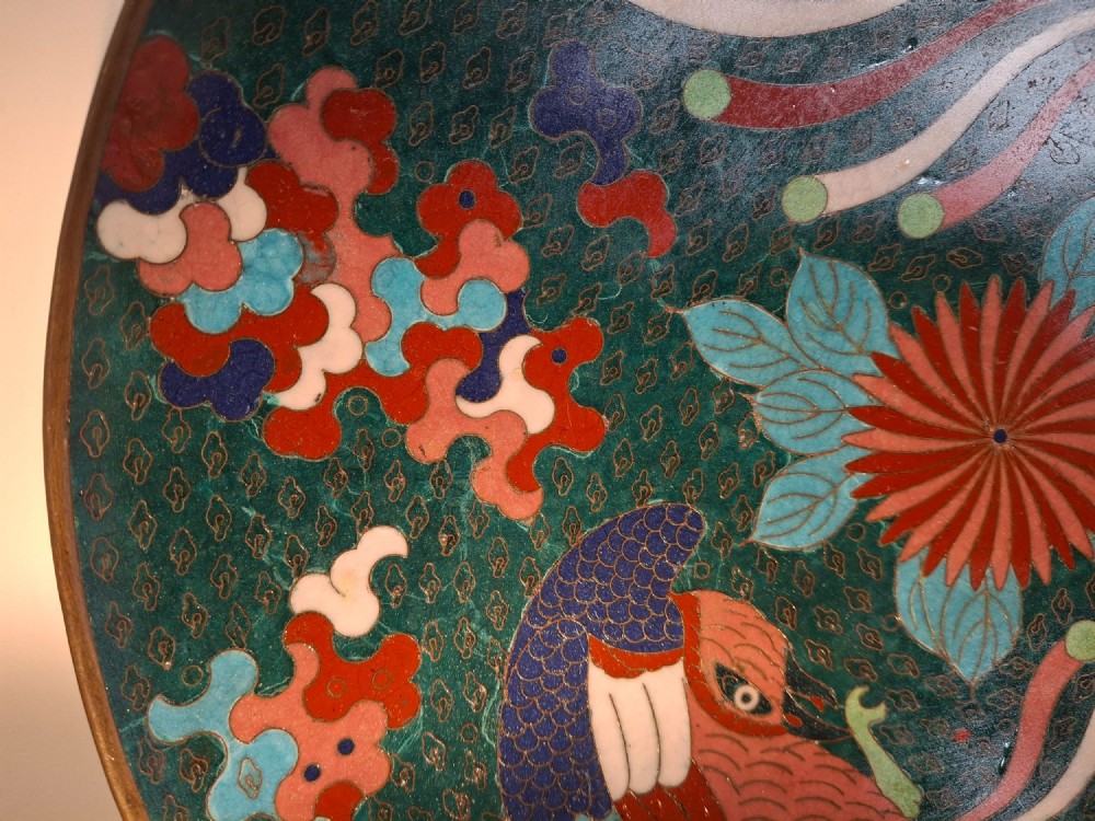 A circular antique Japanese cloisonne enamel charger decorated with two colourful Ho-o phoenix birds and a central floral chrysanthemum motif against a dark teal pattern. View VI