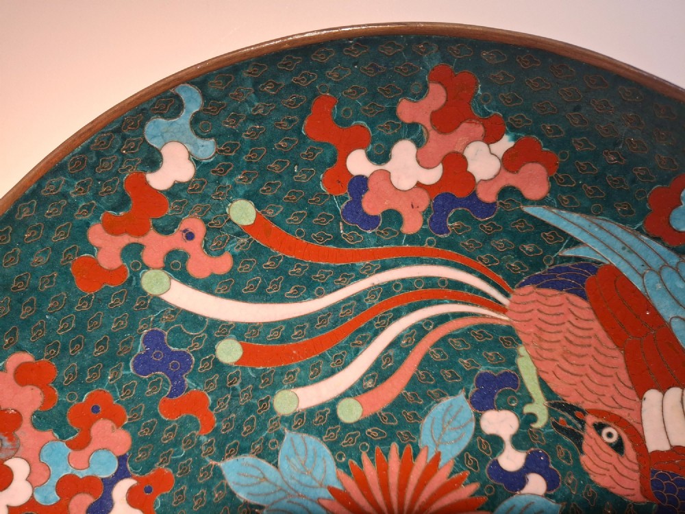 A circular antique Japanese cloisonne enamel charger decorated with two colourful Ho-o phoenix birds and a central floral chrysanthemum motif against a dark teal pattern. View VII