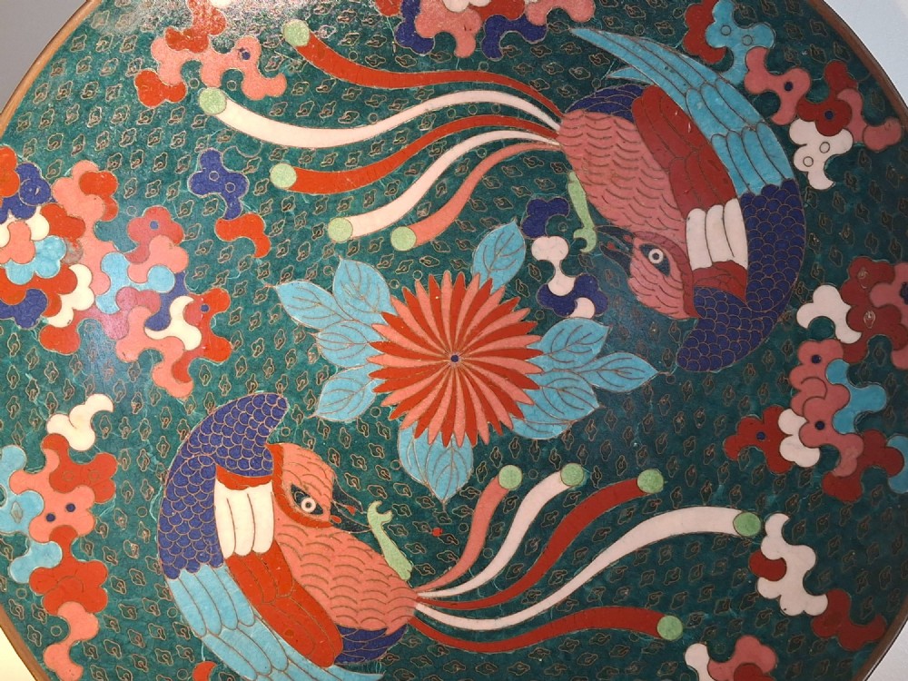 A circular antique Japanese cloisonne enamel charger decorated with two colourful Ho-o phoenix birds and a central floral chrysanthemum motif against a dark teal pattern. View XI