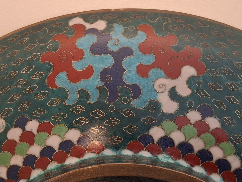 A circular antique Japanese cloisonne enamel charger decorated with two colourful Ho-o phoenix birds and a central floral chrysanthemum motif against a dark teal pattern. View XIII