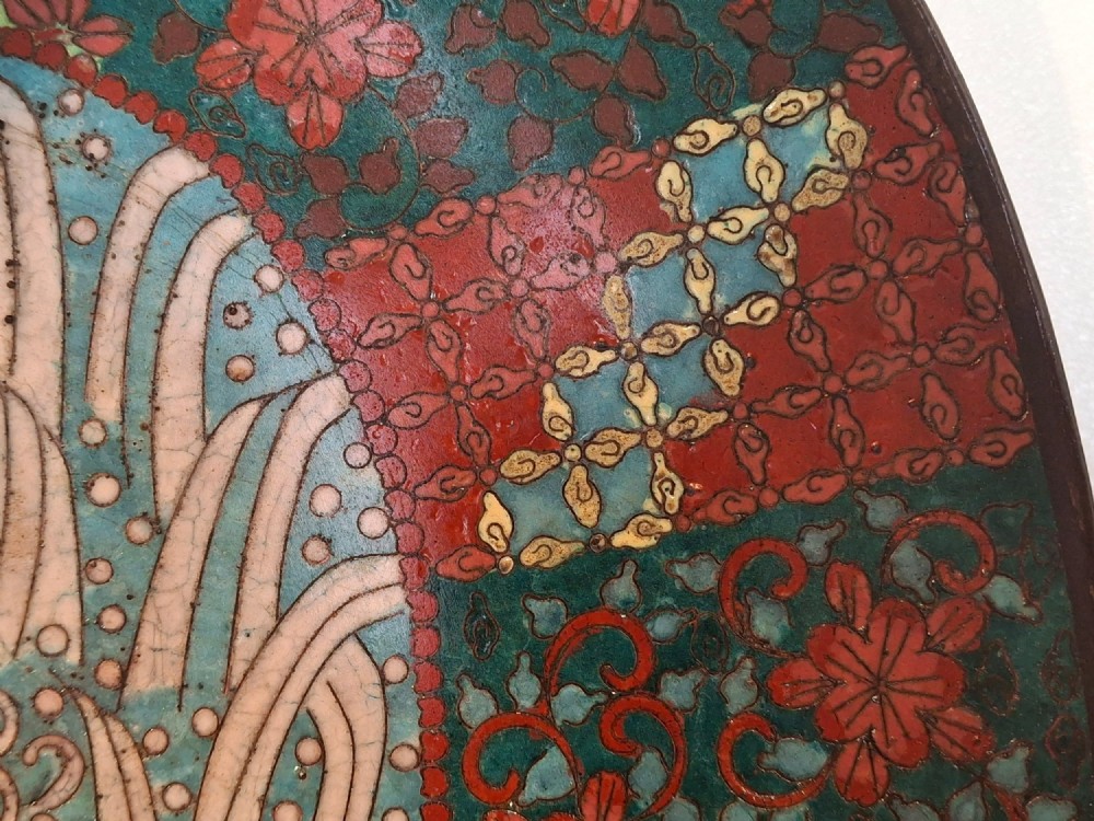 An oval Japanese cloisonne enamel tray displaying a central blue leaping koi carp within stylized waves, surrounded by geometric and red floral patterned borders. View IX