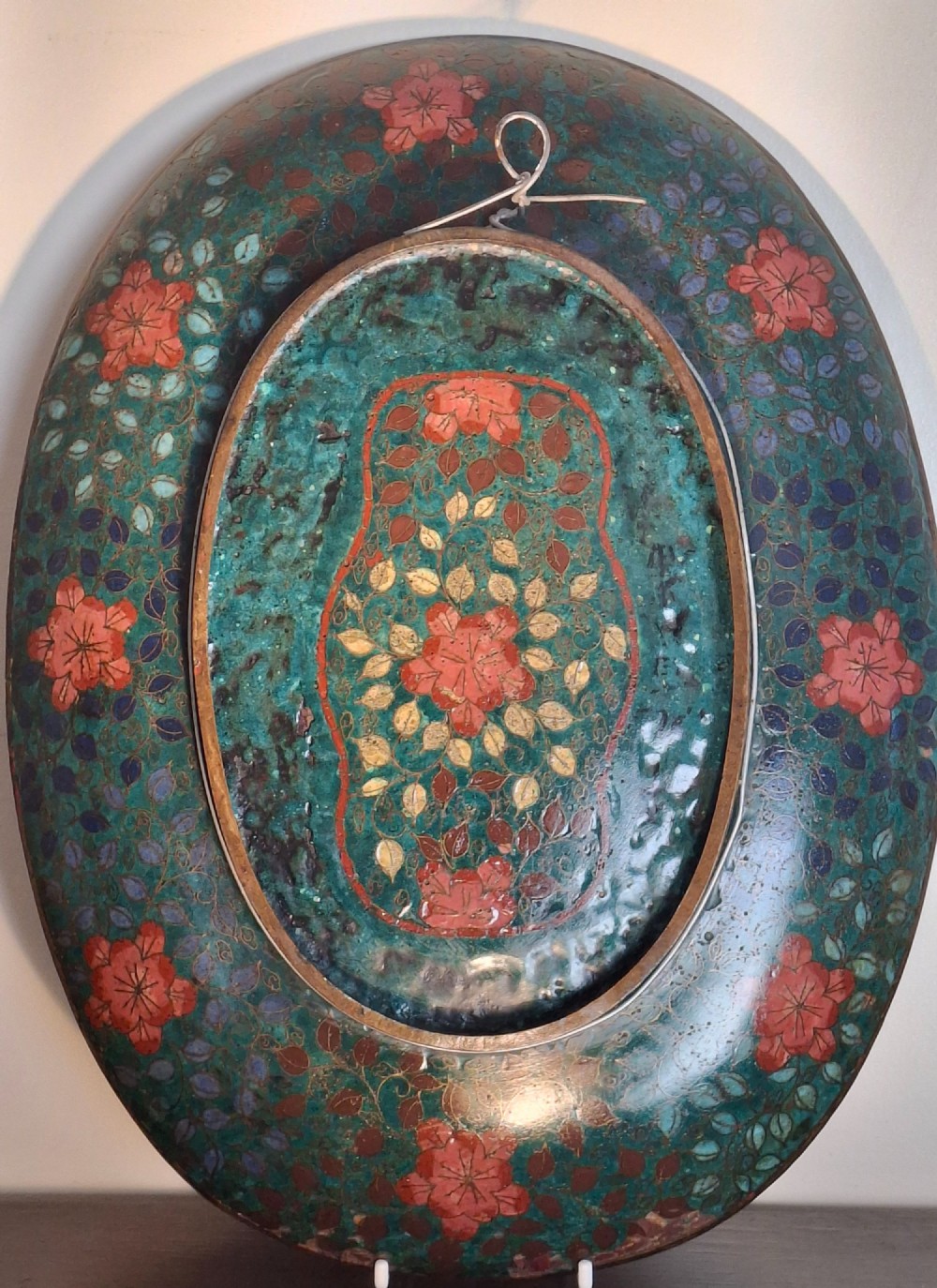An oval Japanese cloisonne enamel tray displaying a central blue leaping koi carp within stylized waves, surrounded by geometric and red floral patterned borders. View XII