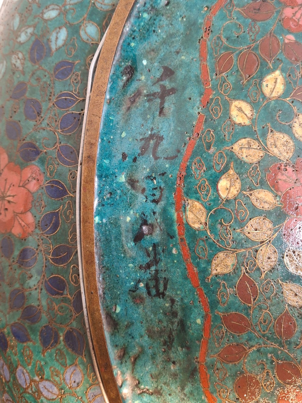 An oval Japanese cloisonne enamel tray displaying a central blue leaping koi carp within stylized waves, surrounded by geometric and red floral patterned borders. View XIV