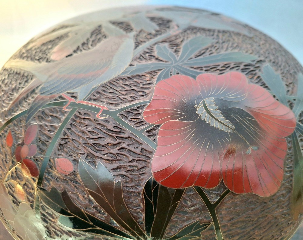 A round antique Japanese Totai Shippo covered box with a textured tree bark enamel surface decorated with red flowers, birds, and brass rim detailing. View VI