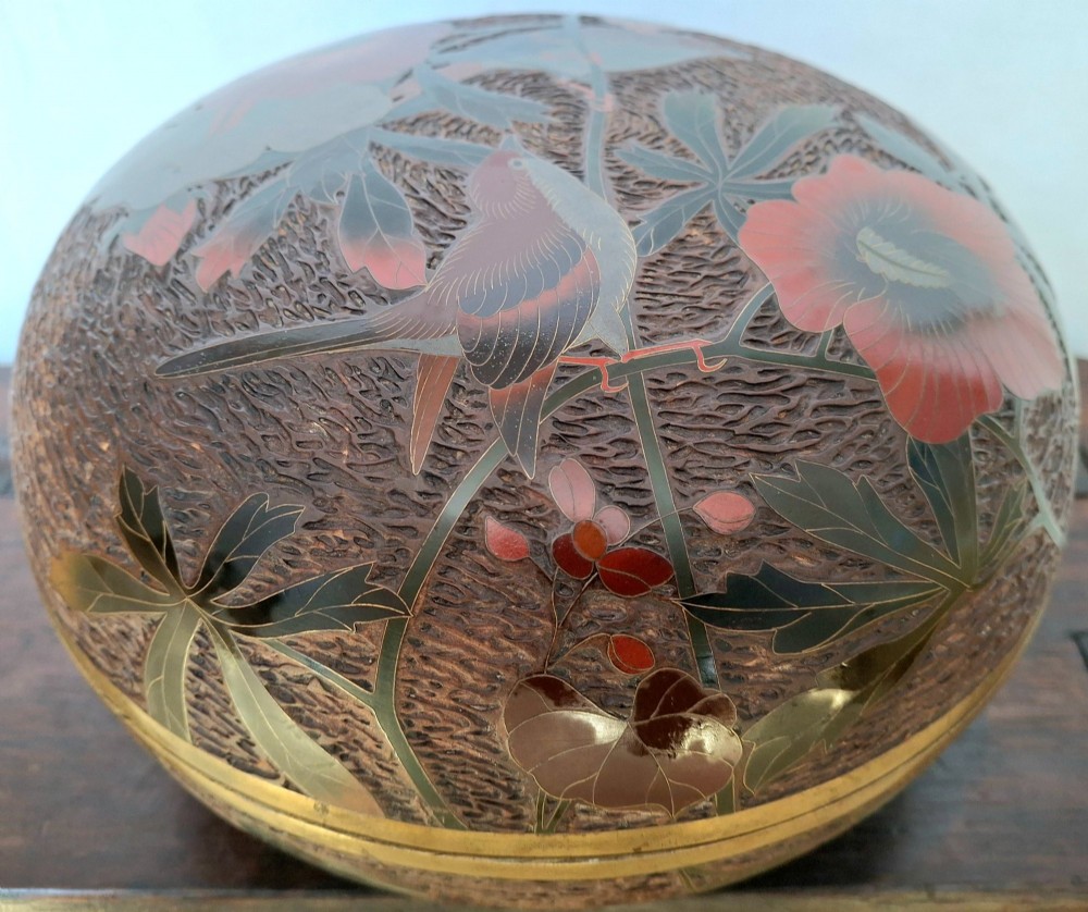 A round antique Japanese Totai Shippo covered box with a textured tree bark enamel surface decorated with red flowers, birds, and brass rim detailing. View XII