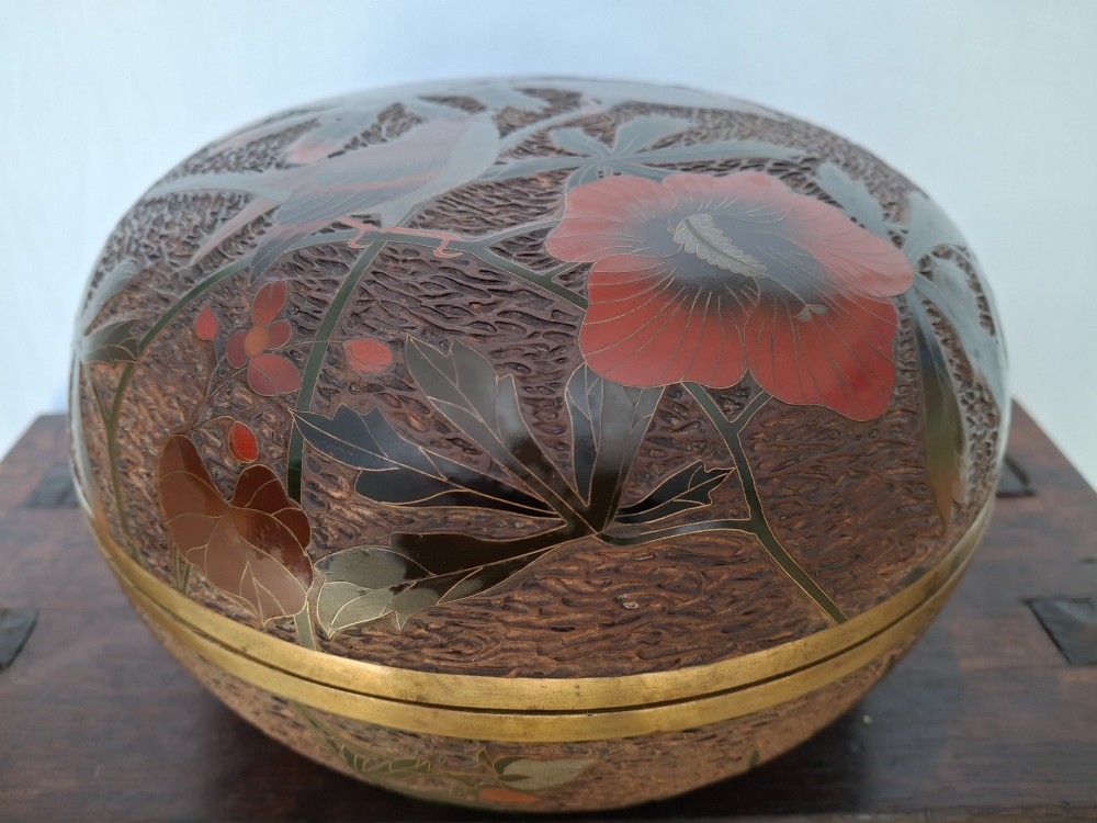 A round antique Japanese Totai Shippo covered box with a textured tree bark enamel surface decorated with red flowers, birds, and brass rim detailing. View XIV