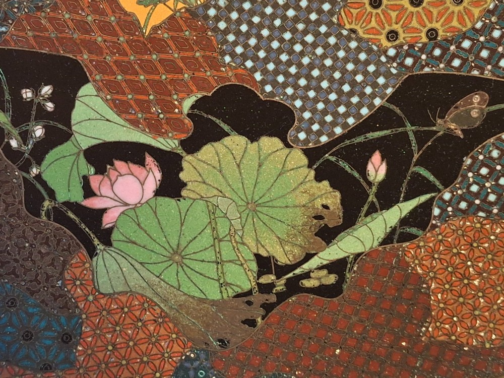 A circular Japanese cloisonne enamel dish featuring a central yellow reserve with a bird and chrysanthemums alongside lotus flowers against geometric mosaic patterns. View III