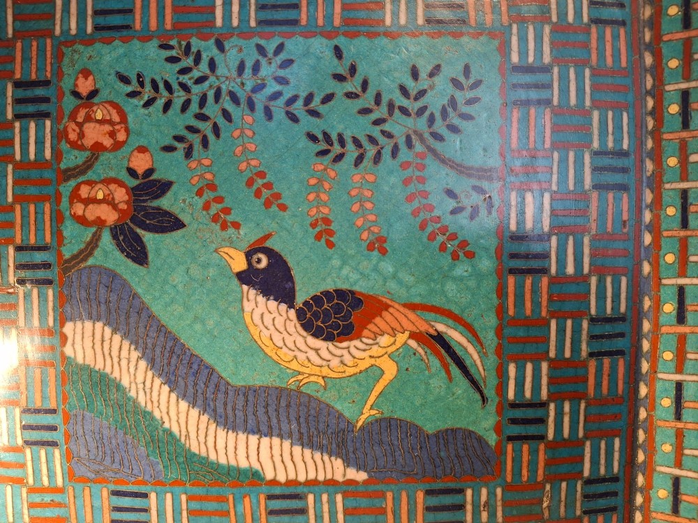 A square Japanese cloisonne enamel tray featuring a central panel with a bird and floral blossoms surrounded by turquoise geometric lattice borders. View IV