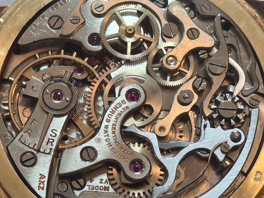 A 1940s Benrus Sky Chief gold chronograph wristwatch with a triple date display and dark brown leather strap. View IX