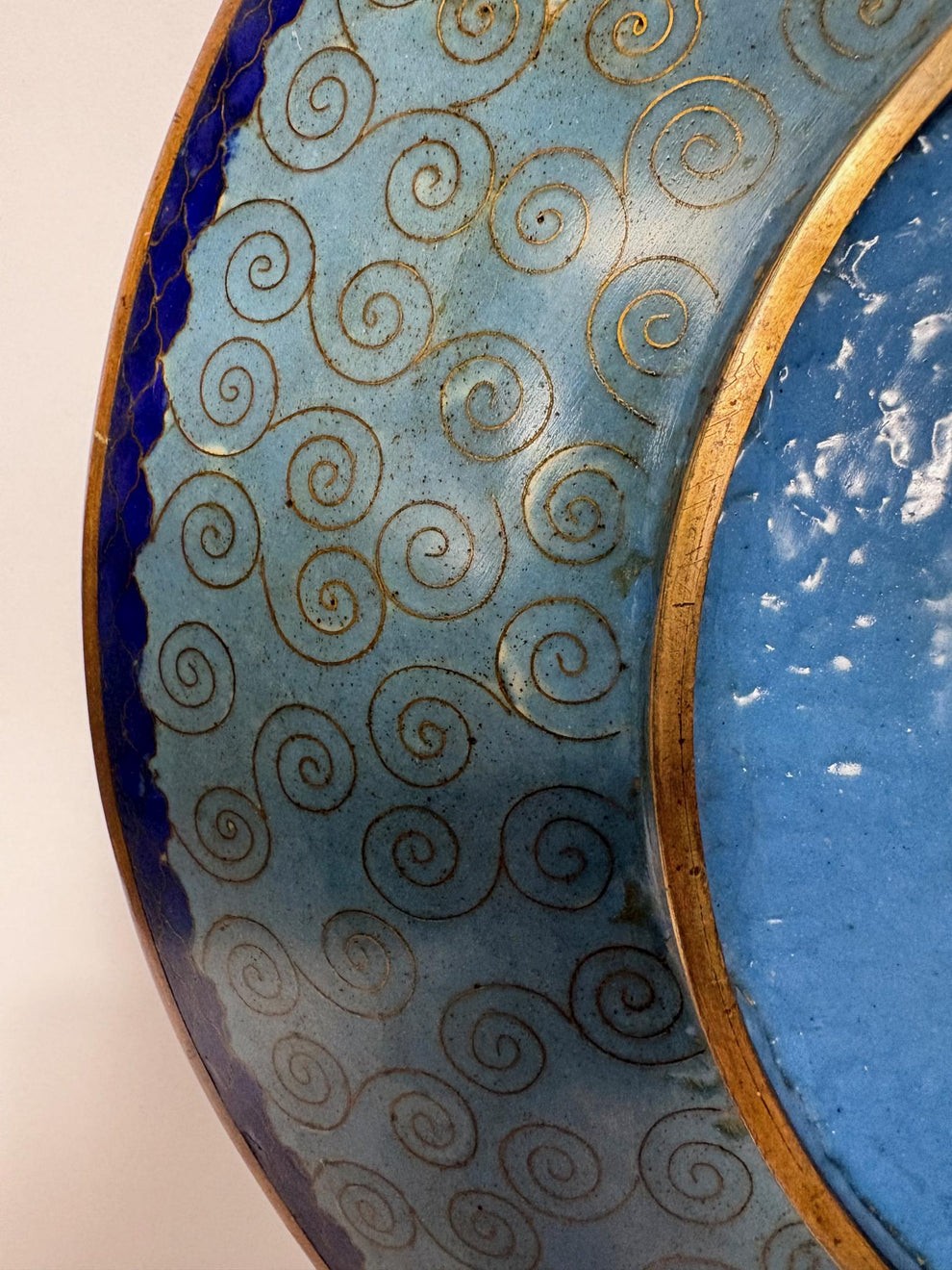 A circular Japanese Meiji period cloisonne charger featuring a sky-blue central medallion with chrysanthemums, a butterfly, and a frog, framed by geometric enamel patterns. View IX