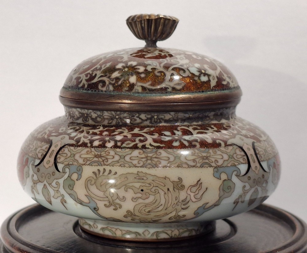 A Japanese cloisonne enamel koro decorated with phoenix motifs and intricate floral scrollwork, topped with a domed lid and carved finial. View IV