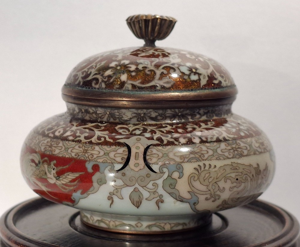 A Japanese cloisonne enamel koro decorated with phoenix motifs and intricate floral scrollwork, topped with a domed lid and carved finial. View VIII