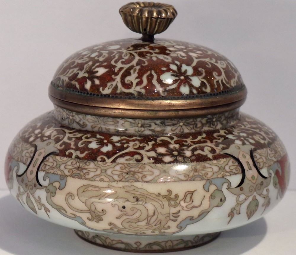A Japanese cloisonne enamel koro decorated with phoenix motifs and intricate floral scrollwork, topped with a domed lid and carved finial. View IX