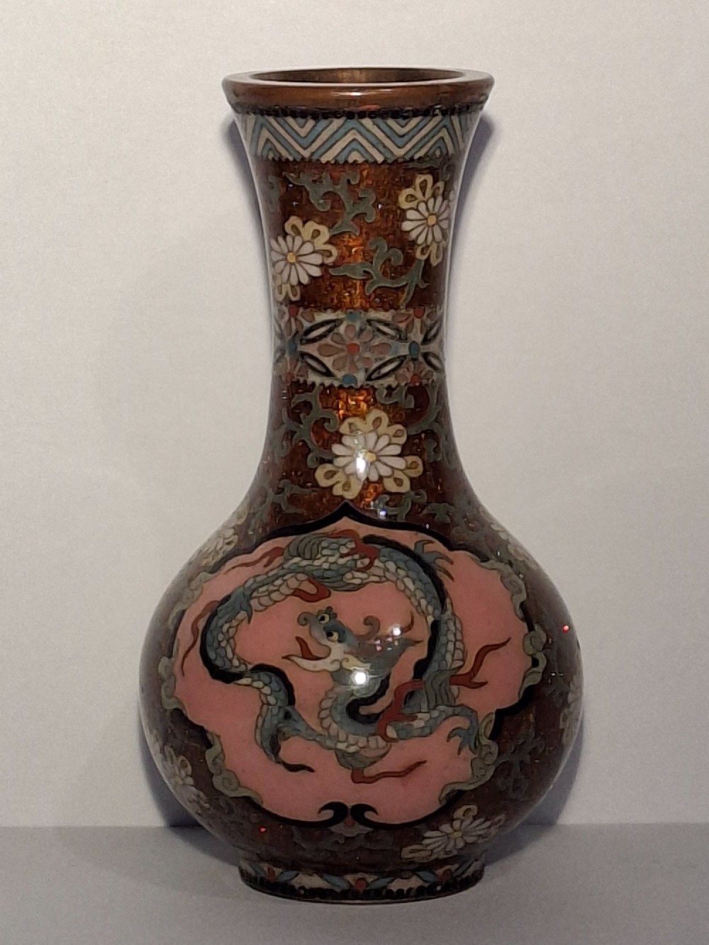 A pair of Japanese Meiji period cloisonne enamel miniature vases featuring detailed dragon and phoenix medallions on brown and light blue grounds. View V