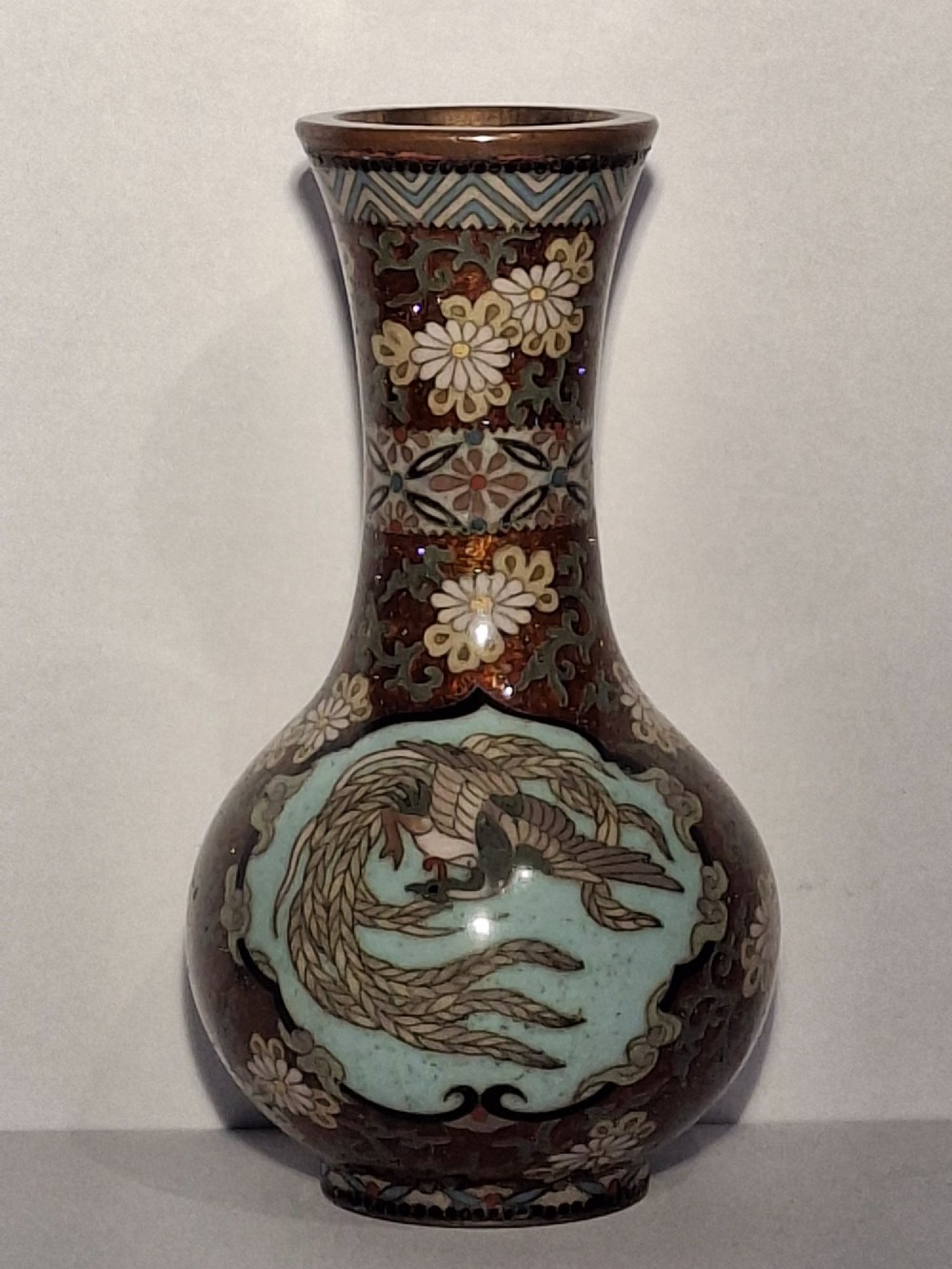 A pair of Japanese Meiji period cloisonne enamel miniature vases featuring detailed dragon and phoenix medallions on brown and light blue grounds. View VI