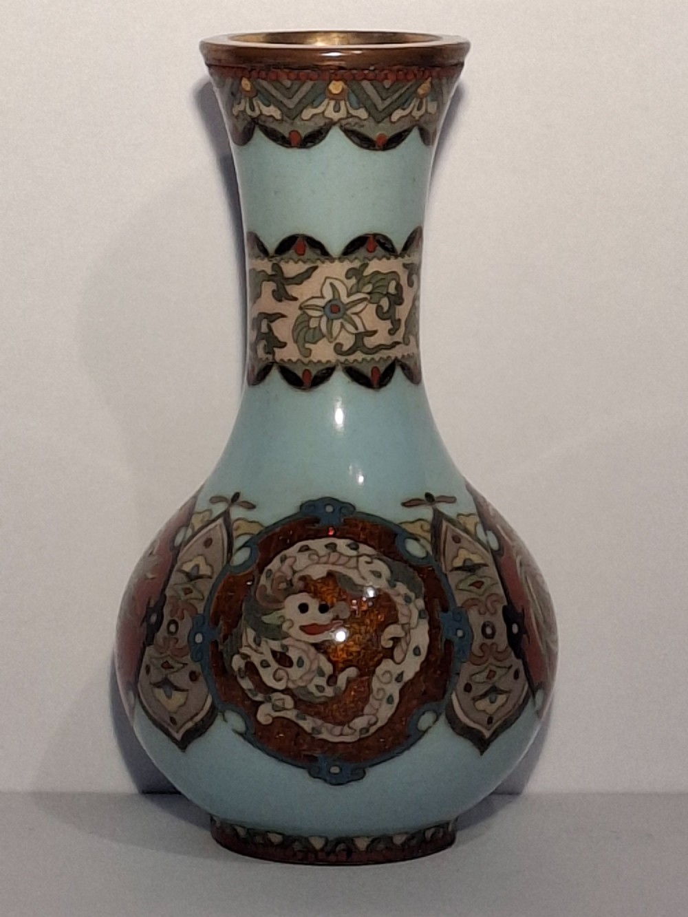 A pair of Japanese Meiji period cloisonne enamel miniature vases featuring detailed dragon and phoenix medallions on brown and light blue grounds. View IX
