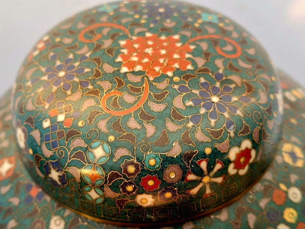 A pair of rounded Japanese cloisonne enamel ginger jars decorated with dense green foliage scrollwork and colourful floral motifs with domed lids. View V