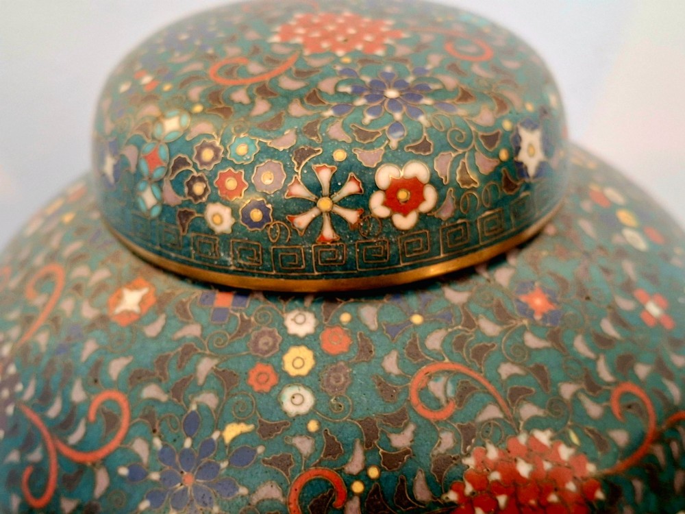 A pair of rounded Japanese cloisonne enamel ginger jars decorated with dense green foliage scrollwork and colourful floral motifs with domed lids. View VIII
