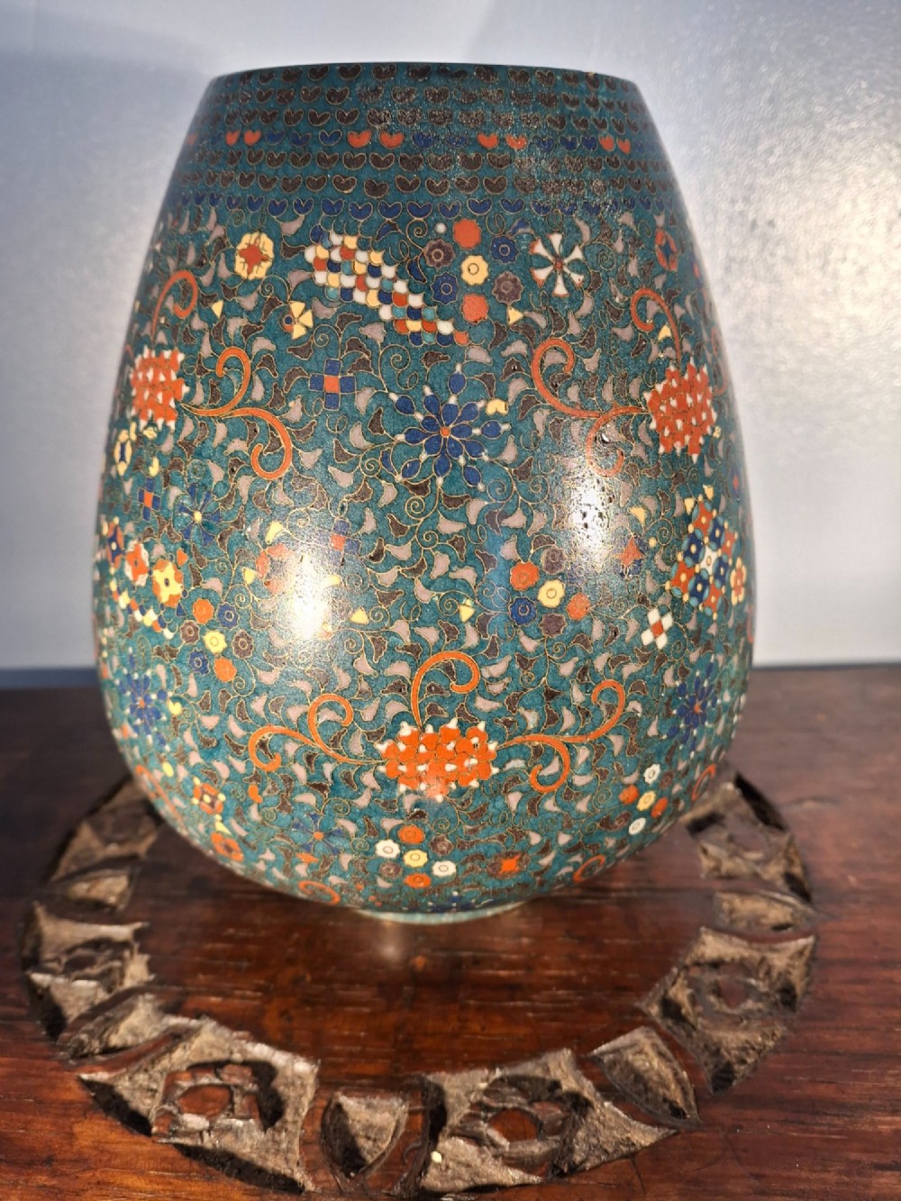 A pair of rounded Japanese cloisonne enamel ginger jars decorated with dense green foliage scrollwork and colourful floral motifs with domed lids. View X