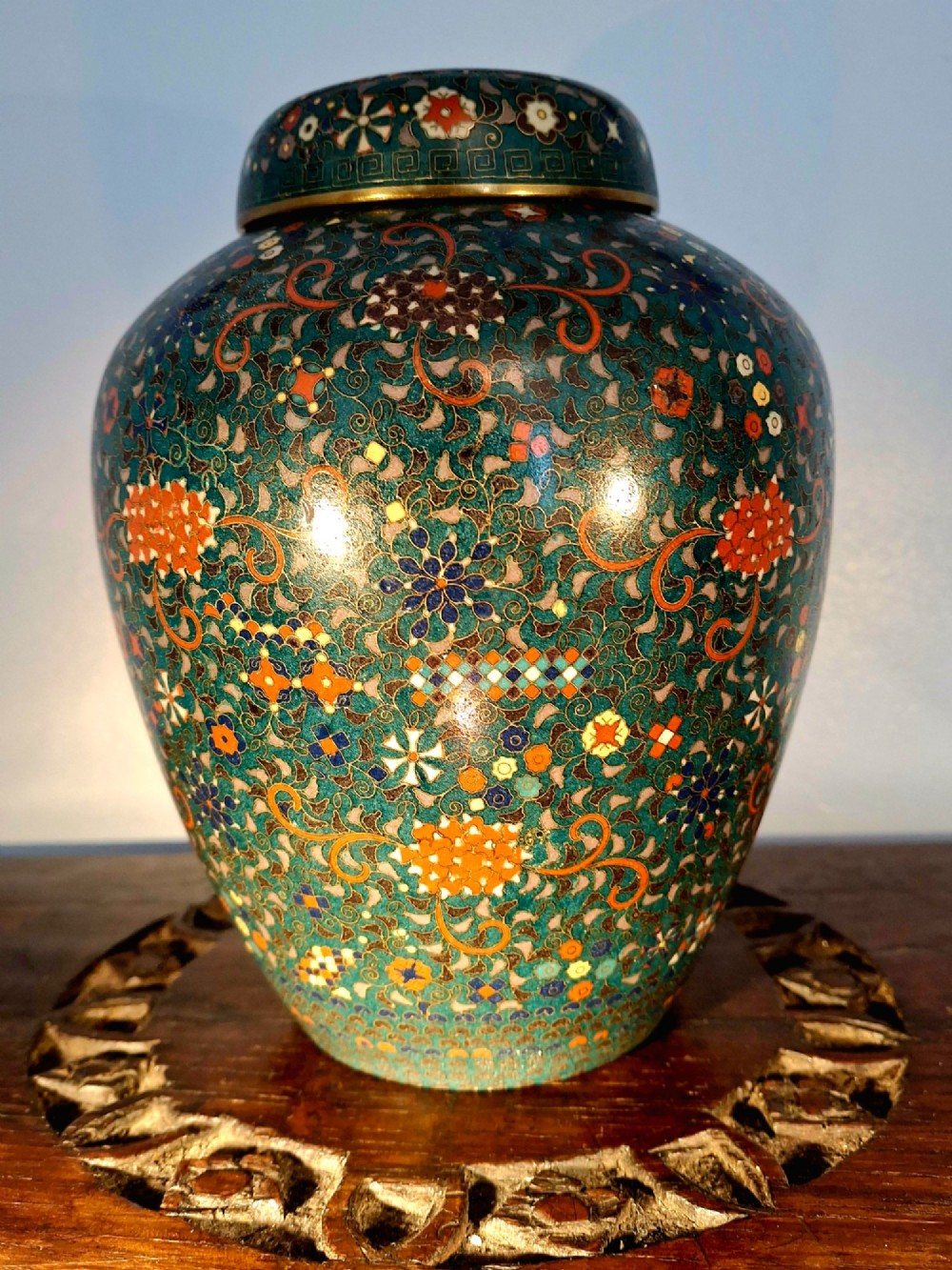 A pair of rounded Japanese cloisonne enamel ginger jars decorated with dense green foliage scrollwork and colourful floral motifs with domed lids. View XV
