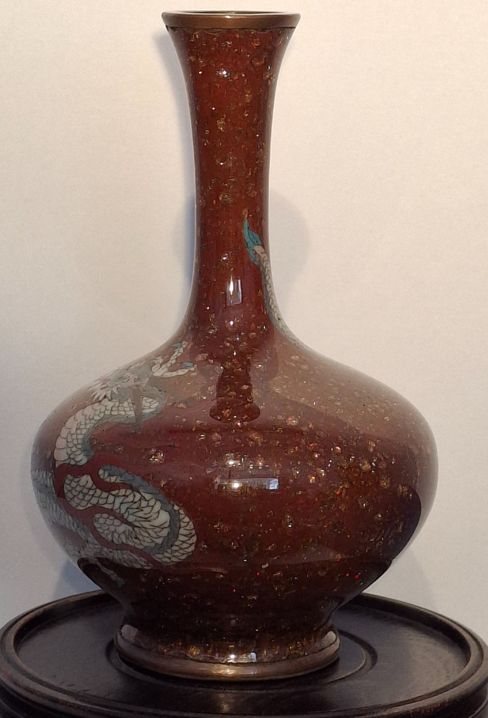 A miniature dark red Japanese cloisonne enamel vase featuring a detailed coiled dragon motif and a slender neck. View II
