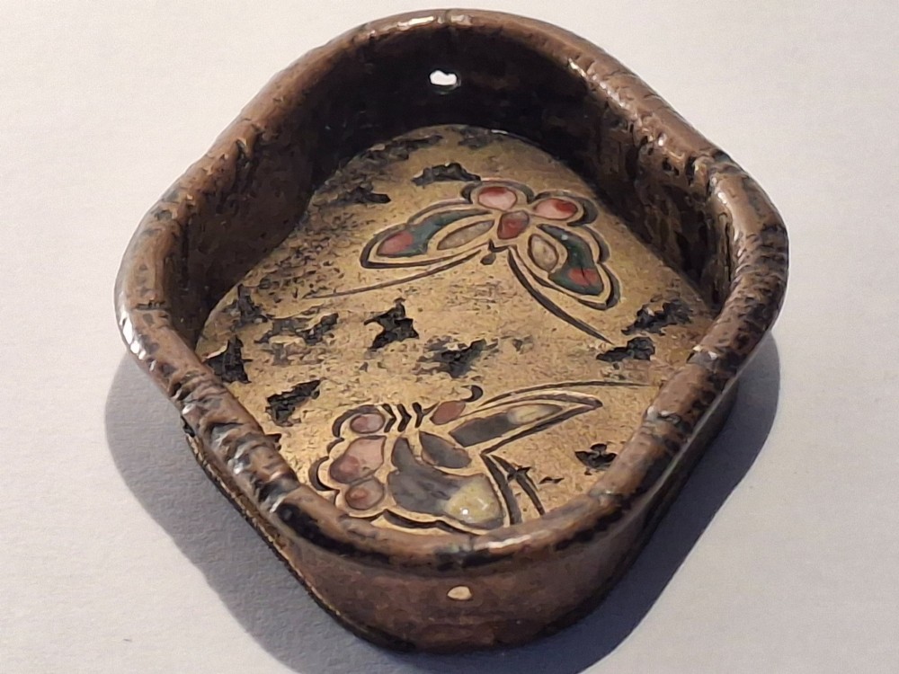 An oval-shaped antique Japanese bronze recessed door pull featuring two decorative enamel butterflies against a textured gilded background. View IV