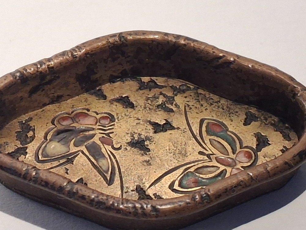 An oval-shaped antique Japanese bronze recessed door pull featuring two decorative enamel butterflies against a textured gilded background. View V