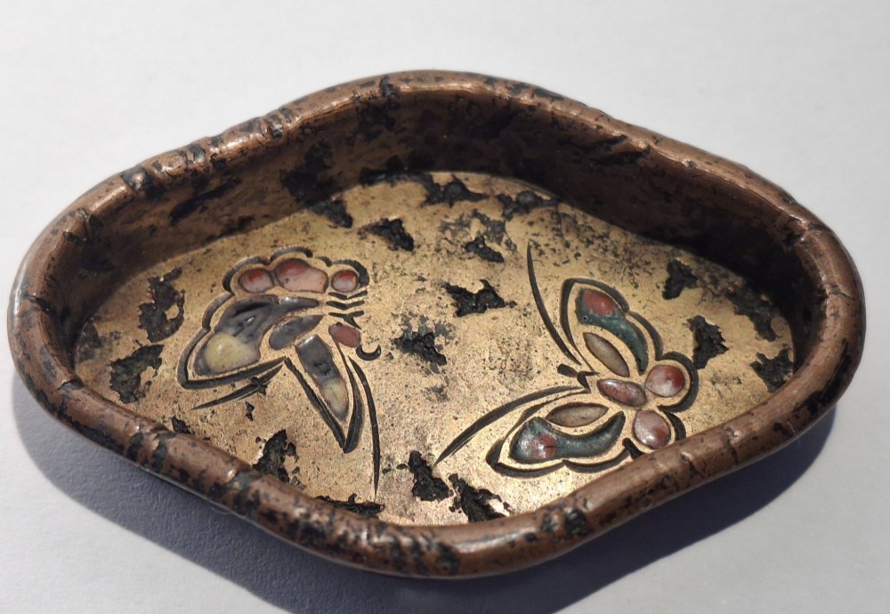 An oval-shaped antique Japanese bronze recessed door pull featuring two decorative enamel butterflies against a textured gilded background. View VI