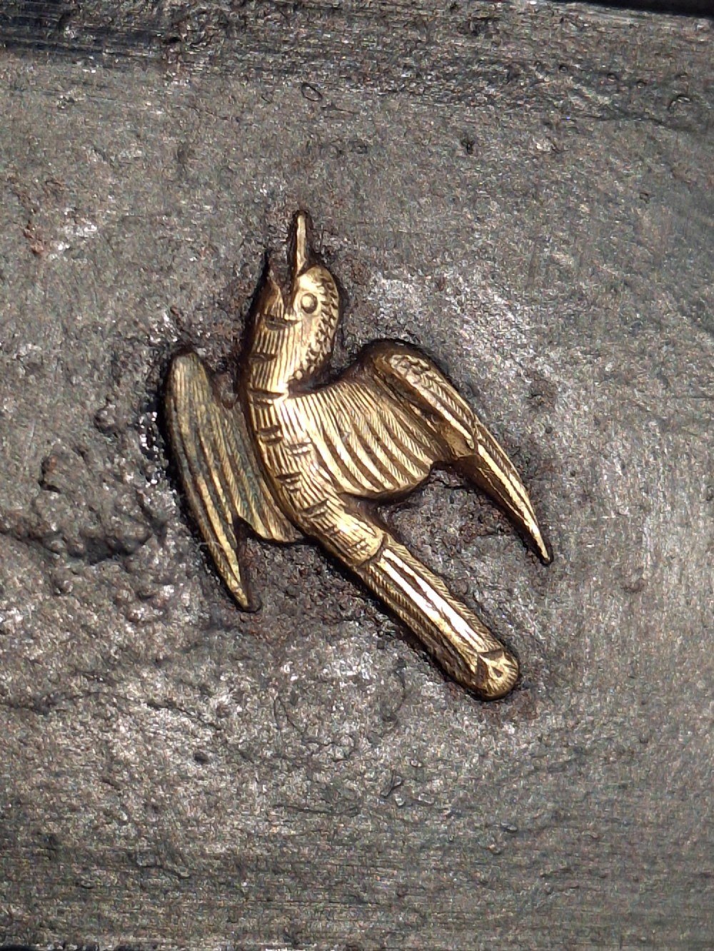 A rectangular dark bronze recessed Japanese hikite door pull decorated with a gilt bird in flight and carved pine tree motifs. View V