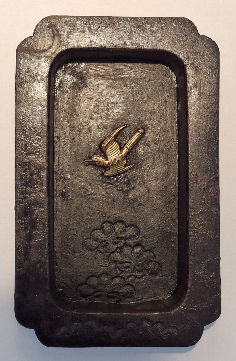 A rectangular dark bronze recessed Japanese hikite door pull decorated with a gilt bird in flight and carved pine tree motifs. View VII