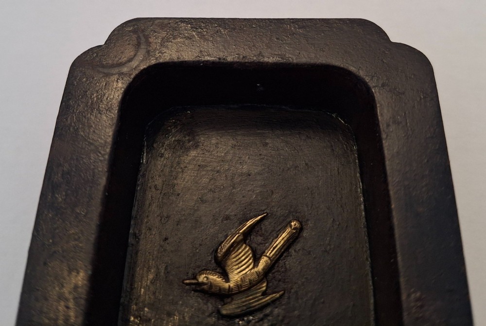 A rectangular dark bronze recessed Japanese hikite door pull decorated with a gilt bird in flight and carved pine tree motifs. View XIII