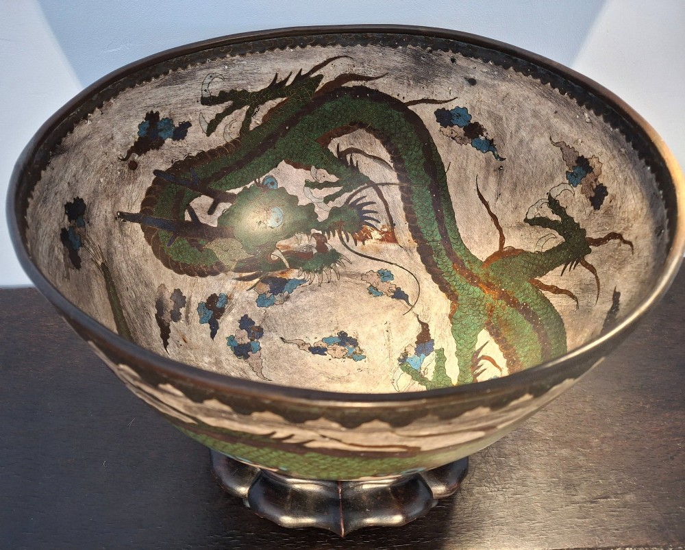 A large Japanese cloisonne enamel bowl featuring green dragon motifs, displayed on a carved dark wooden stand. View II