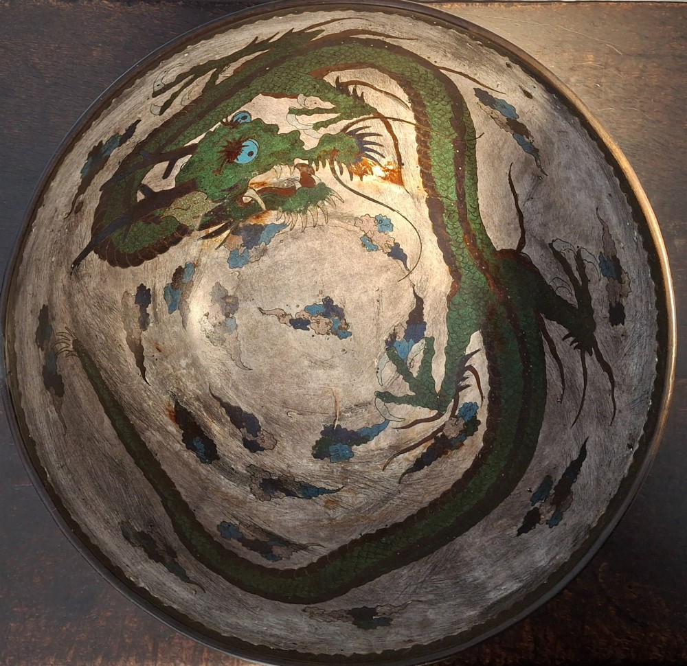 A large Japanese cloisonne enamel bowl featuring green dragon motifs, displayed on a carved dark wooden stand. View III