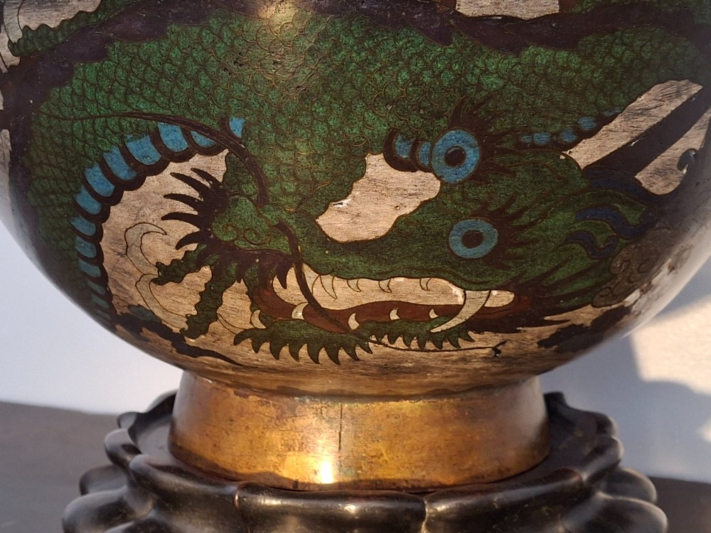 A large Japanese cloisonne enamel bowl featuring green dragon motifs, displayed on a carved dark wooden stand. View VII