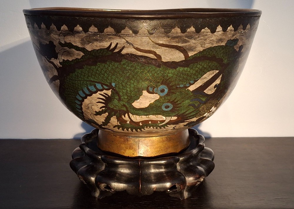 A large Japanese cloisonne enamel bowl featuring green dragon motifs, displayed on a carved dark wooden stand. View XV