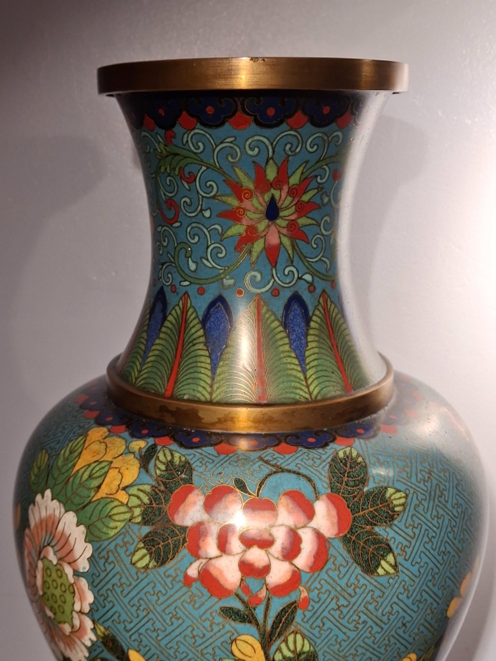 A large Chinese cloisonne enamel vase with pink and yellow floral motifs over a blue geometric ground and brass rim. View VI