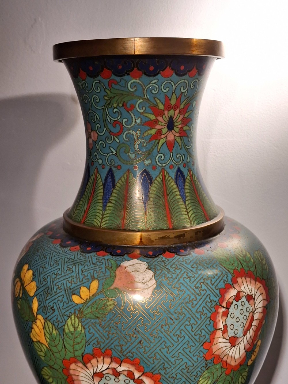 A large Chinese cloisonne enamel vase with pink and yellow floral motifs over a blue geometric ground and brass rim. View VIII