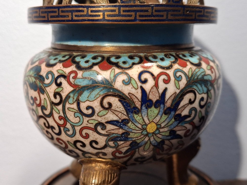 A 19th-century Chinese tripod cloisonne enamel censer featuring intricate floral scrollwork, upright loop handles, three gilded cabriole feet, and a pierced brass cover. View VIII