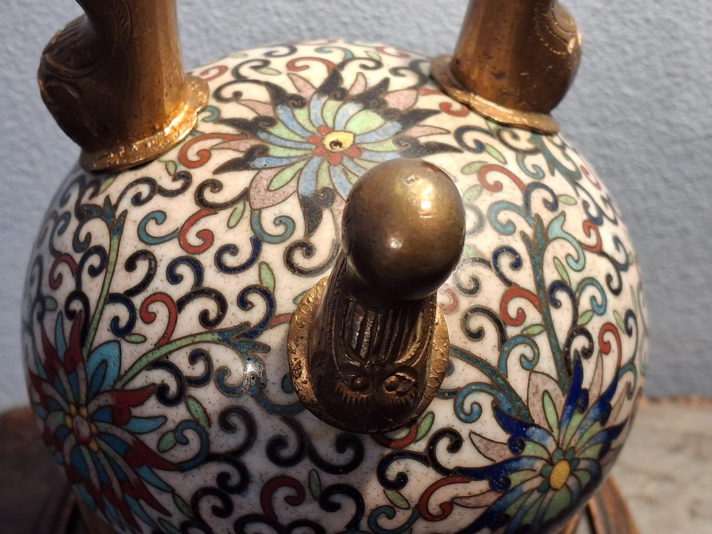 A 19th-century Chinese tripod cloisonne enamel censer featuring intricate floral scrollwork, upright loop handles, three gilded cabriole feet, and a pierced brass cover. View XV