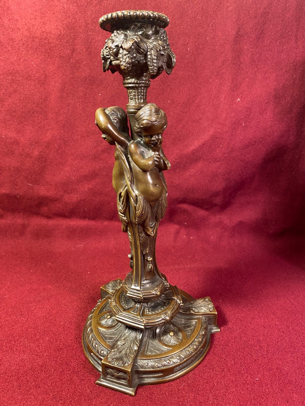 A pair of cast patinated bronze candlesticks featuring stems sculpted with putti figures and ornate stepped bases decorated with acanthus motifs. View II