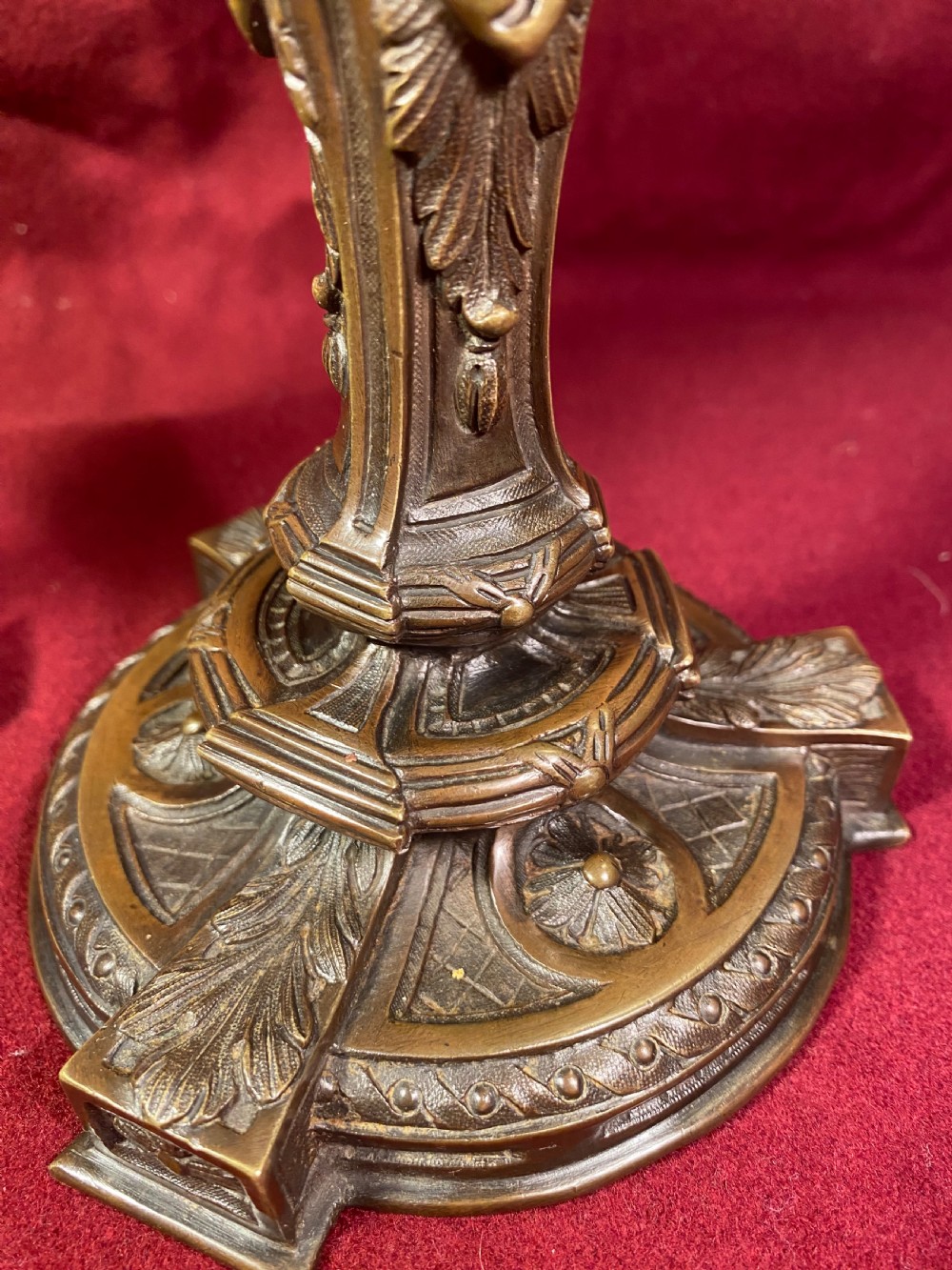 A pair of cast patinated bronze candlesticks featuring stems sculpted with putti figures and ornate stepped bases decorated with acanthus motifs. View VIII