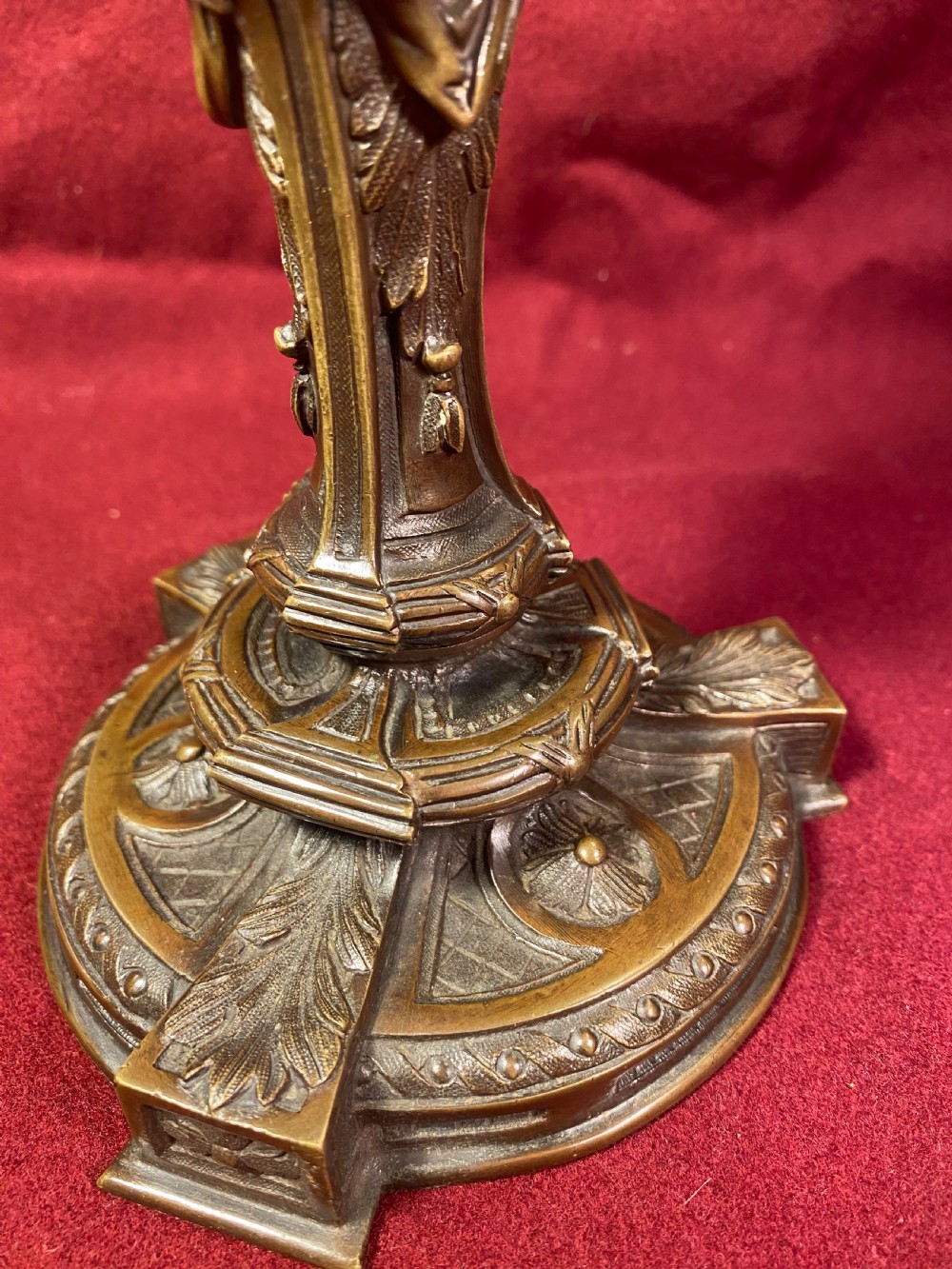 A pair of cast patinated bronze candlesticks featuring stems sculpted with putti figures and ornate stepped bases decorated with acanthus motifs. View IX