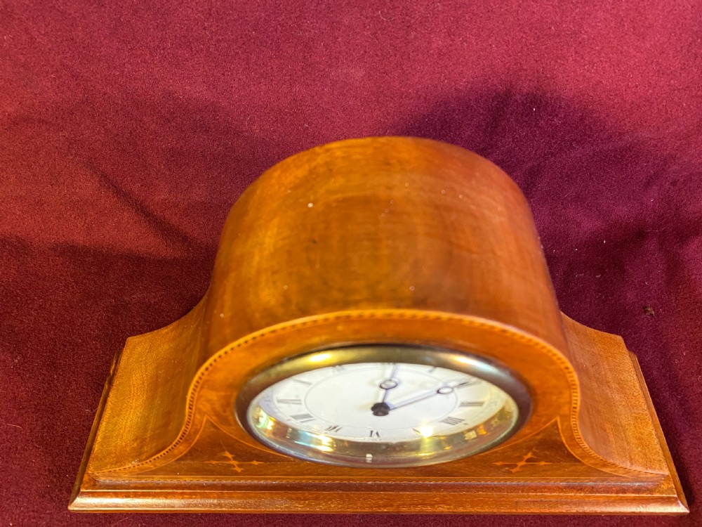 An Edwardian satinwood mantel clock featuring an arched case with geometric cross marquetry, a white Roman numeral dial, and a brass bezel. View III